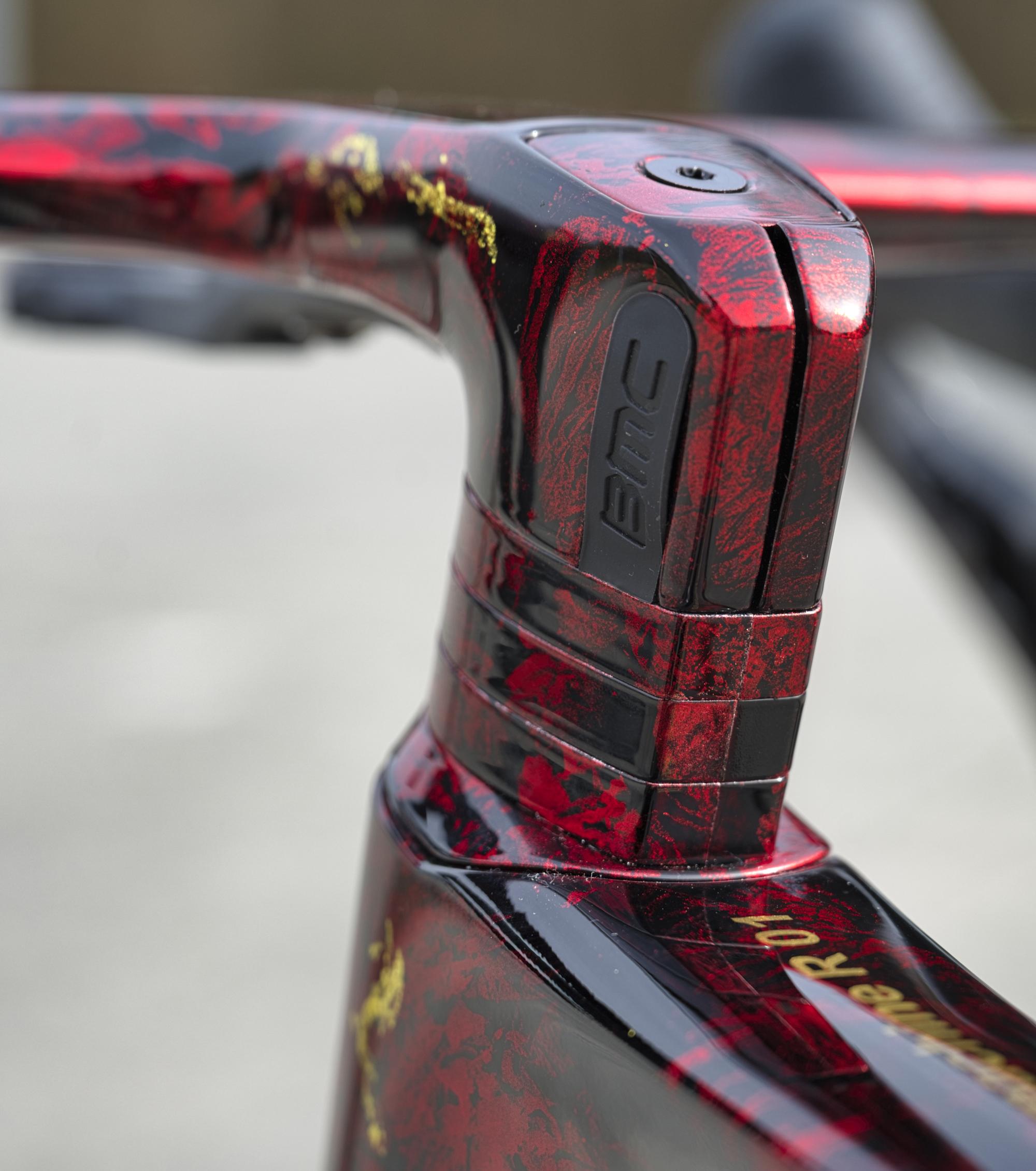 Gros plan sur la peinture personnalisée or et rouge d'un BMC Teammachine